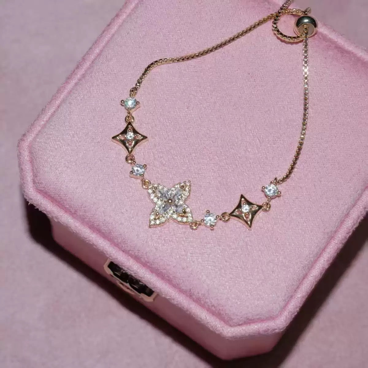 Iris Bloom Zircon Bracelet with a delicate gold-tone chain, clear sparkling stones, and floral motifs with diamond-shaped accents.