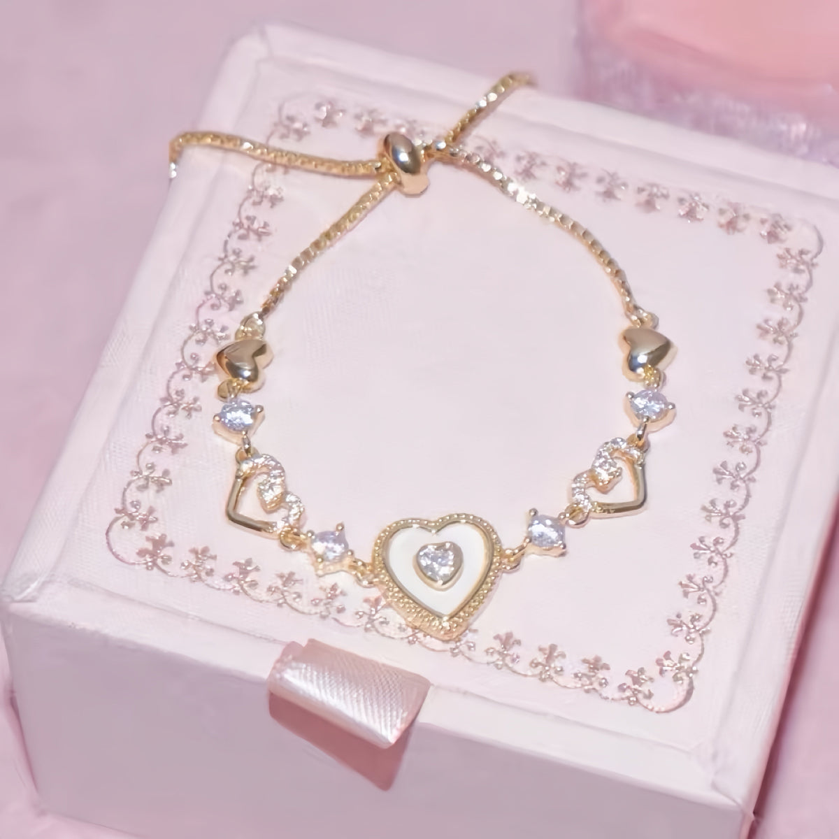 Sweet Holiday Heart Bracelet in gold-tone metal, with a central layered heart charm and sparkling clear stones.